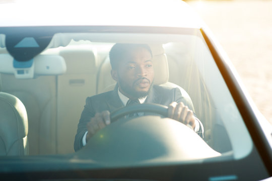 Serious Businessman Driving Luxury Car, View From Windshield