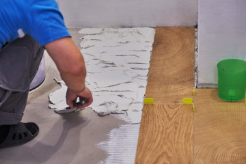 close-up of handyman placing tile spacer. Placing the floor tiles. Home improvement