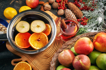 Christmas drink mulled wine, fruit and spices on a wooden table