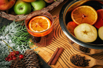 Christmas drink mulled wine, fruit and spices on a wooden table