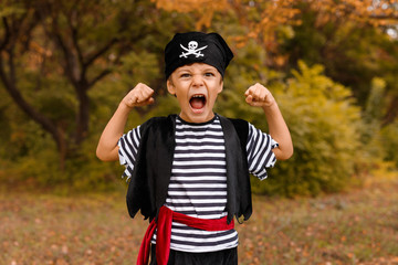 Obraz premium Mały chłopiec w stroju pirata pokazując siłę