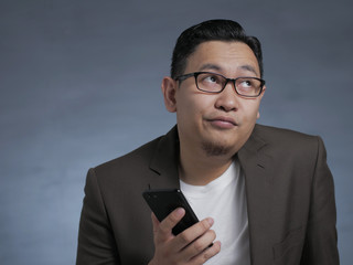 Young Man Thinking While Chatting on Smart Phone