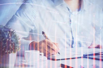 Double exposure of man's hands writing notes of stock market with forex chart.