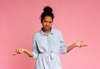 Young african american girl displeased about something, spreading hands