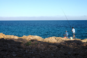 Fototapeta na wymiar man fishing on the beach