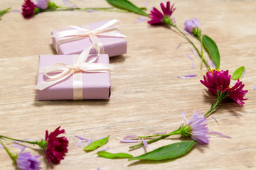 Purple gift boxes. Flowers on a wooden table. Valentine's day concept. Mother's Day Scenery