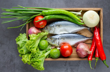 Raw Mackerel on stone cutting board with Thai style vegetable ready for cook.