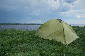 Tent by the river in cloudy weather