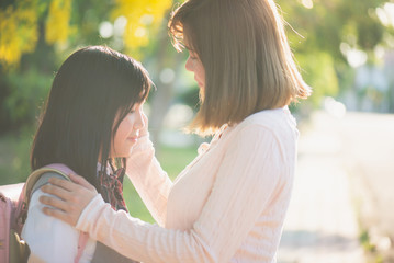Asian mother saying goodbye to her daughter as she leave for School,back to school concept