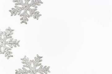 Xmas frame pattern made of big silver snowflakes isolated on white background