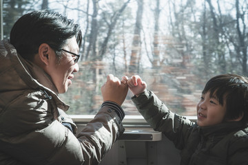 Asian father and his son making a pinkie promise