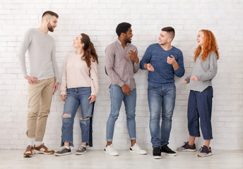 Young stylish friends talking, having break at college