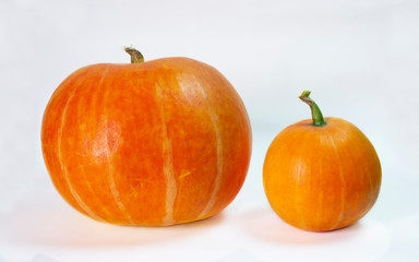 two orange pumpkins on top of each other on an isolated background