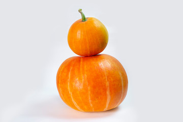 two orange pumpkins on top of each other on an isolated background