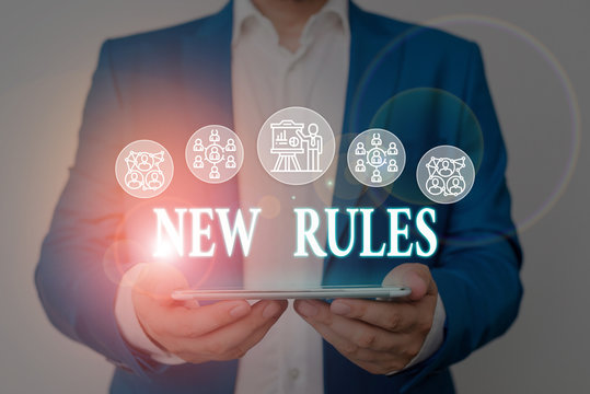 Writing note showing New Rules. Business concept for A state of changing an iplemented policy for better upgrade Male wear formal work suit presenting presentation smart device