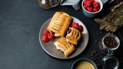 Drożdżówka francuska z malinami i kremem. Ciemne tło, widok z góry.