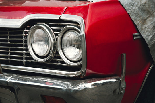 Classic American retro car under car case on the street. Bumper and headlight of red vintage car. - Powered by Adobe