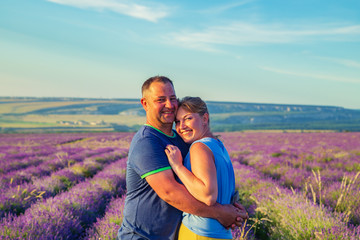 Loving couple in a lavender field at sunset. Sunny summer evening.