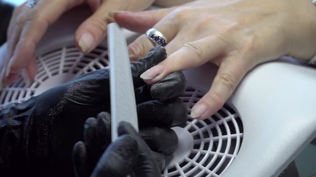 Woman in a nail salon receiving a manicure by a beautician with nail file. Nails manicure. Manicured beauty salon. Manicure Nail Art. Beautiful Nail Art Manicure. Nails designs with decoration