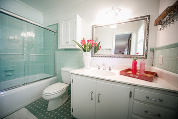 Small outdated tile bathroom with a clear glass door and a white cabinet sink vanity and mirror