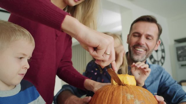 Handheld video shows of family drilling pumpkins for Halloween