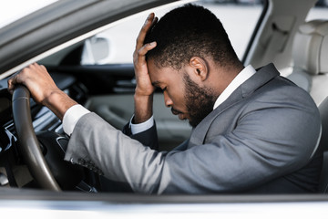 Stressed businessman feeling headache in car, stop the car