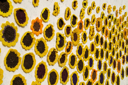 Hand made crochet sun flowers fixed to a wall and pole