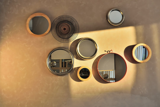 Round Mirrors Of Various Sizes On A Wall Partially