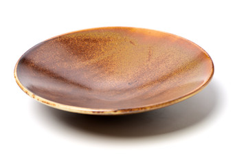 Empty brown earthenware plate on white background