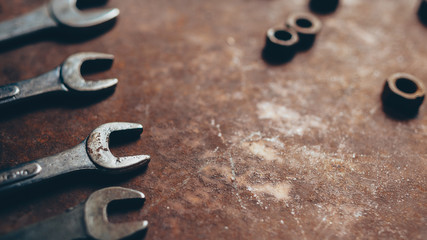 Auto maintenance service. Professional wrench set and nuts on rusty dark metal background. Copy space.