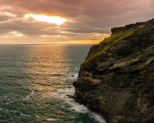 Fototapeta na wymiar sunset. sun creeping through the clouds onto the sea and small island