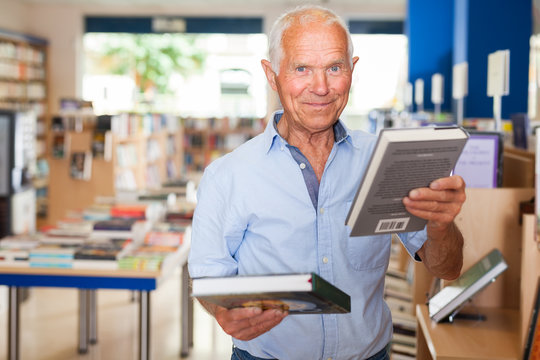 Happy elderly man in bookstore