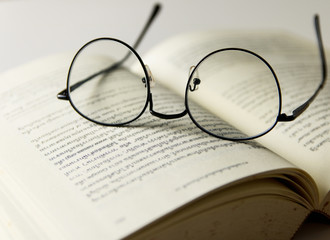 Reading glasses placed on open books