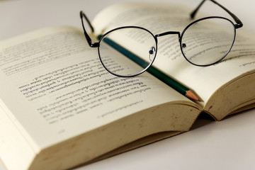 Reading glasses placed on open books