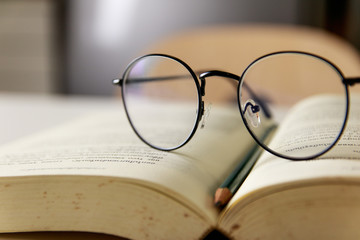 Reading glasses placed on open books