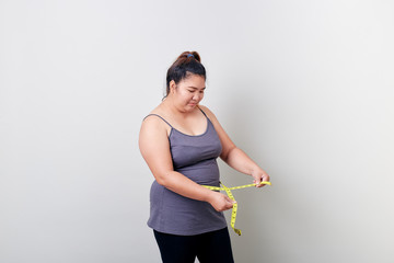 Overweight woman measuring her fat belly