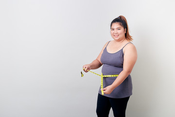 Overweight woman measuring her fat belly