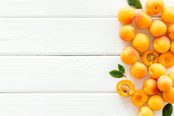 Fruit frame. Apricots and leaves on white wooden background top view copy space
