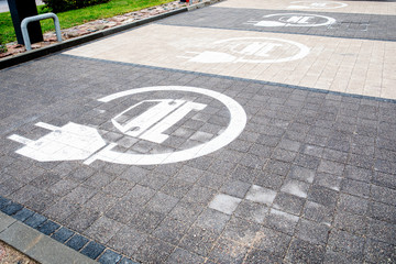 Parking symbol for electric cars being charged. Pavement of different colors