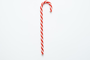 Traditional Christmas edible decoration. Flat lay of striped red candy cane isolated on white background. Copy space.