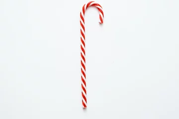 Rolgordijnen Traditional Christmas edible decoration. Flat lay of striped red candy cane isolated on white background. Copy space. © golubovy
