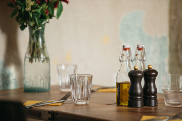 Detail of a wooden table set for dinner in a rustic indoors restaurant