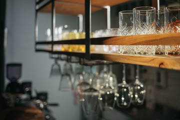 Vintage drinking glasses hanging from a bar rack at a small rustic restaurant at sunset