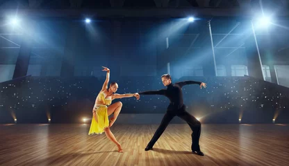Fotobehang Couple dancers  perform latin dance on large professional stage. Ballroom dancing. © VIAR PRO studio