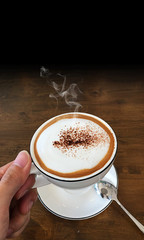 a cup of coffee in hand holding