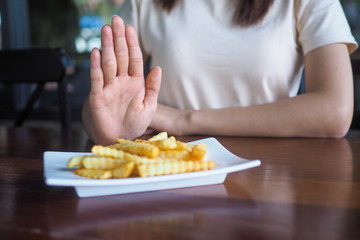Health-care women push the dishes into french fries. Do not eat fried and high-fat foods