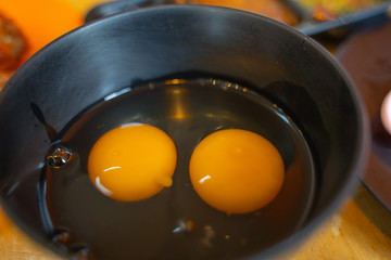 Yellow egg white and yolk baking ingredient in a black bowl