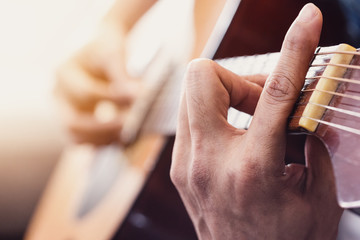 Close up of man's hands playing acoustic guitar