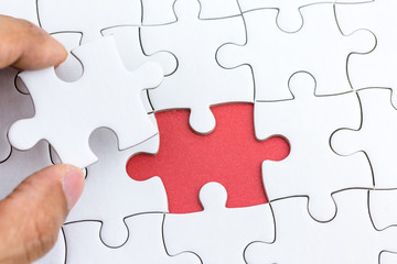 Hand holding piece of jigsaw puzzle