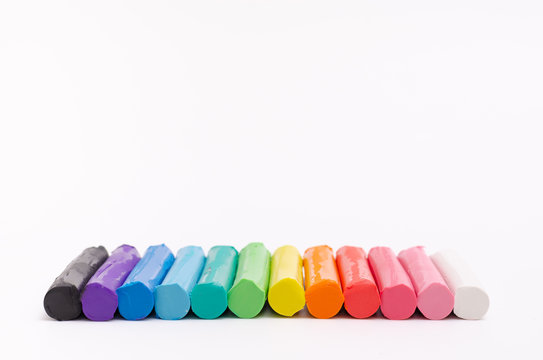Multi-colored modelling clay stacked on a white background.